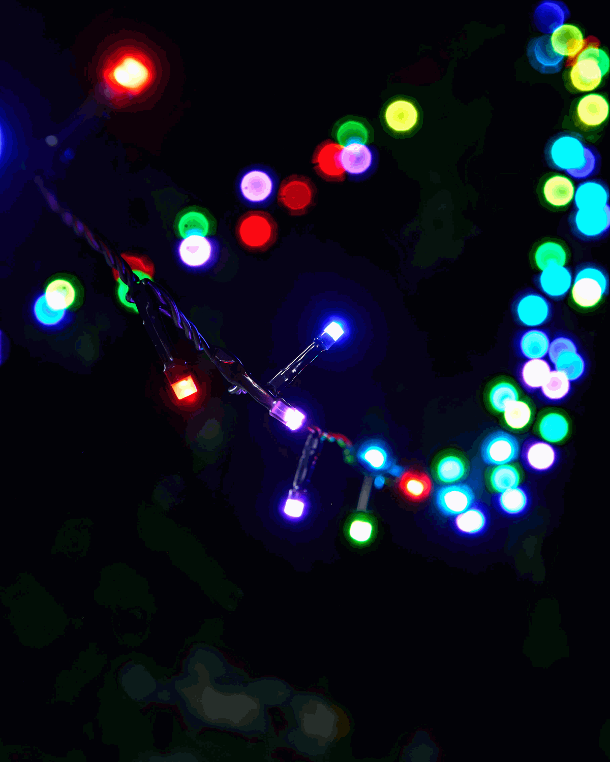 Colour-changing LED string lights hanging down flashing different colours.
