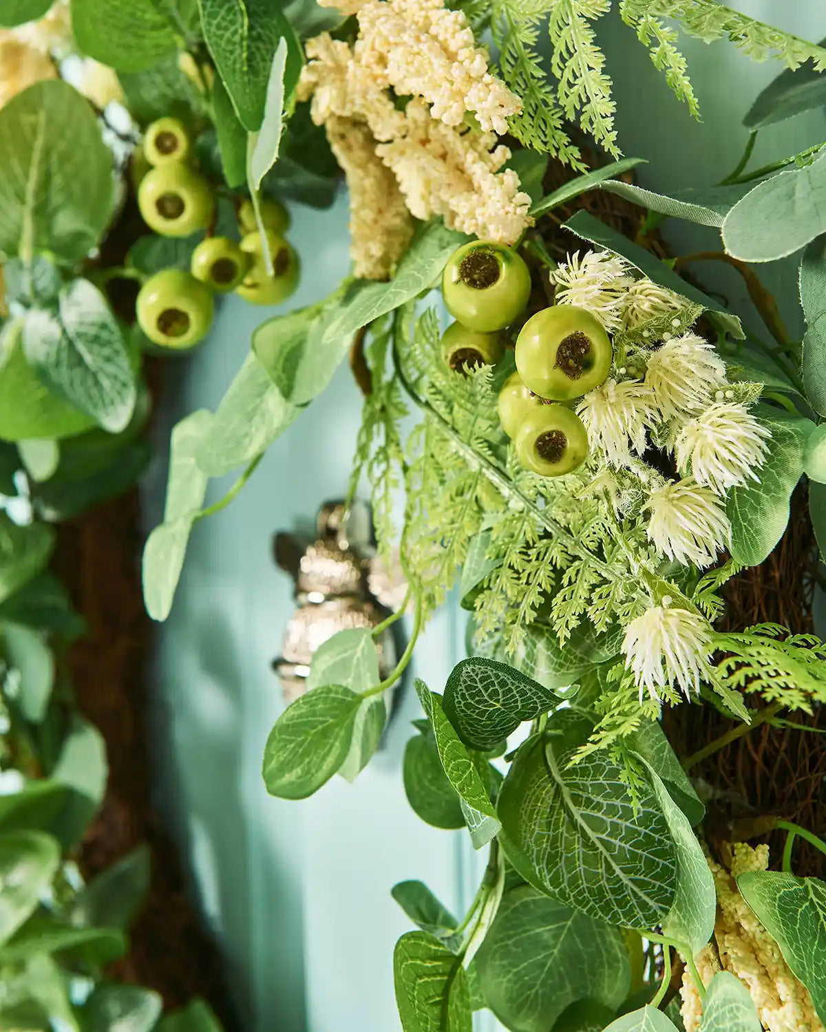 Cream, 28 Inch, Artificial Floral Eucalyptus Spring Wreath,  on a Turquoise door, side angle, close up.