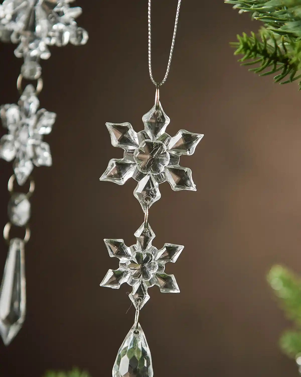 Crystal snowflake ornament hanging against a blurred natural background