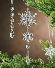 Crystal snowflake ornament hanging on a Christmas tree with a brown background