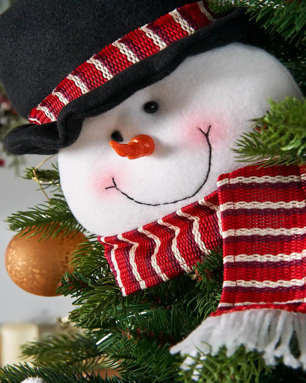 Close up of 3D DIY Snowman face with Red and White Scarf Tree Decoration, 40 cm on a Christmas tree with Gold Bauble 