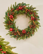 Decorated wreath with Apples and Cinnamon sticks on a cream wall