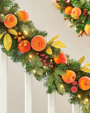 Decorative Christmas garland oranges and peaches and lights on a neutral background