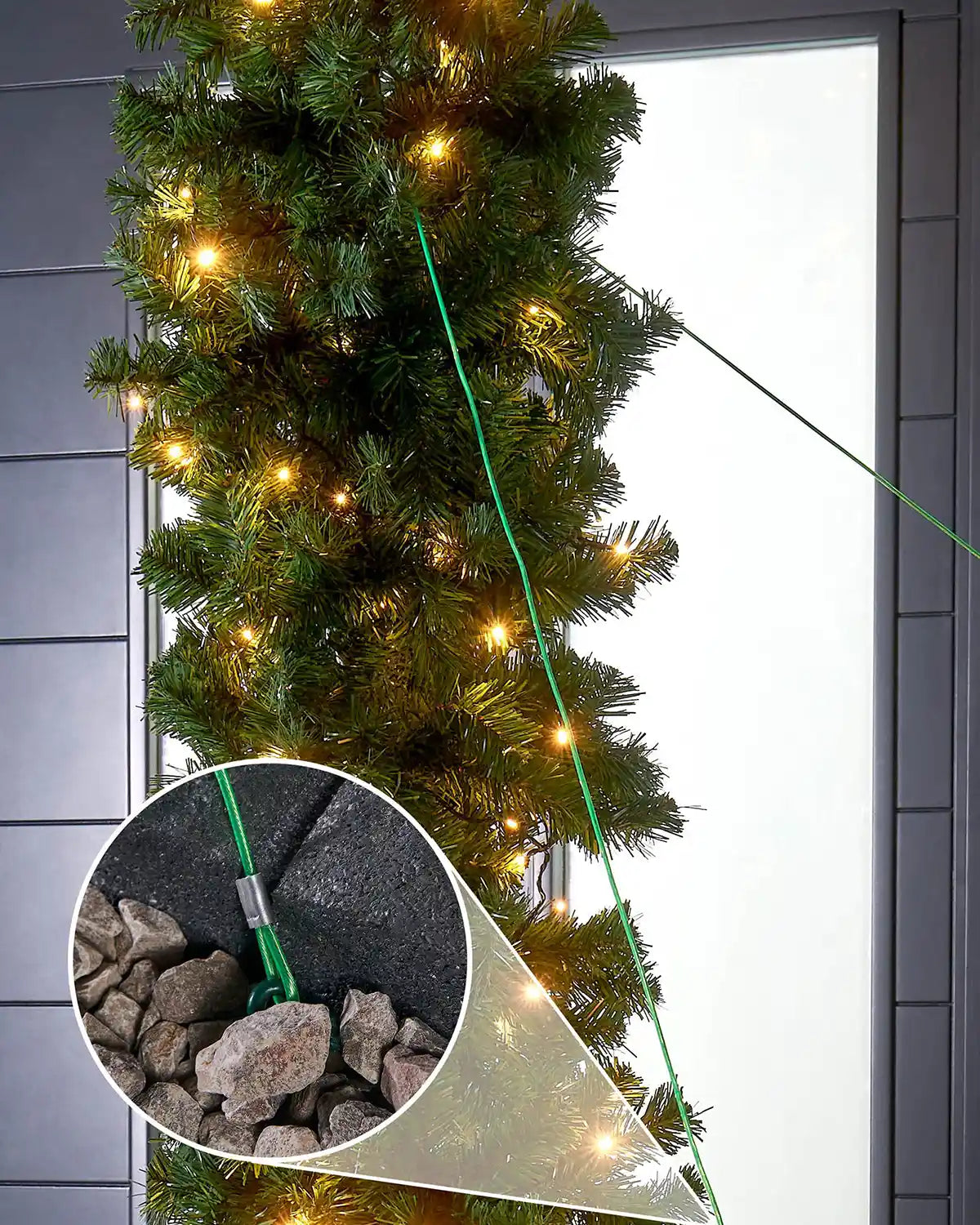 Decorative Christmas garland with lights on a door, inset showing a tool and stones.
