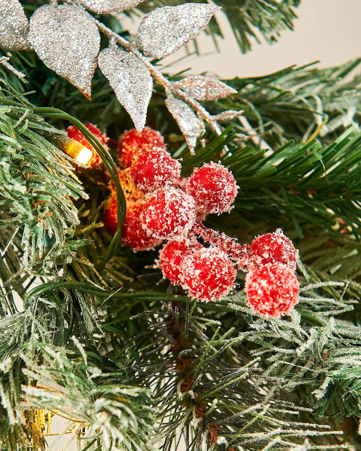 Decorative Christmas garland with red berries and silver leaves on a green background