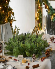 Decorative Christmas table setting with greenery and festive décor.