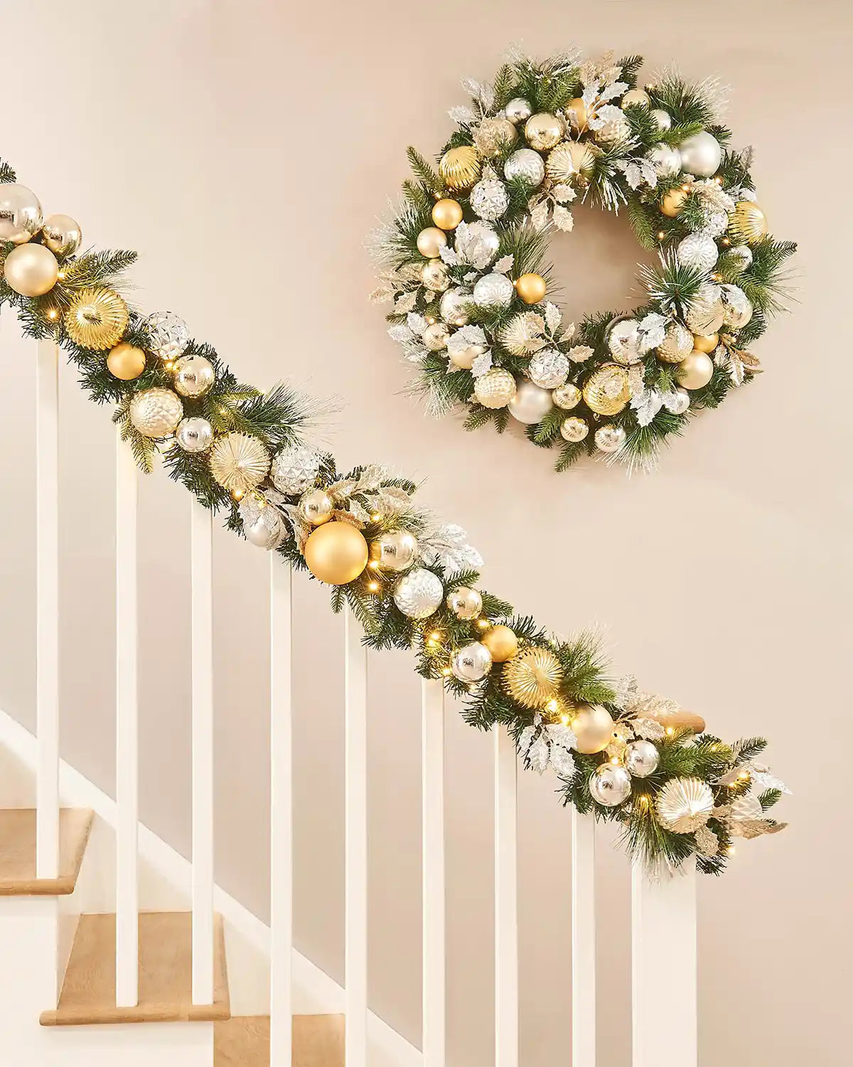 Decorative Christmas wreath and matching garland on a staircase banister with a neutral background