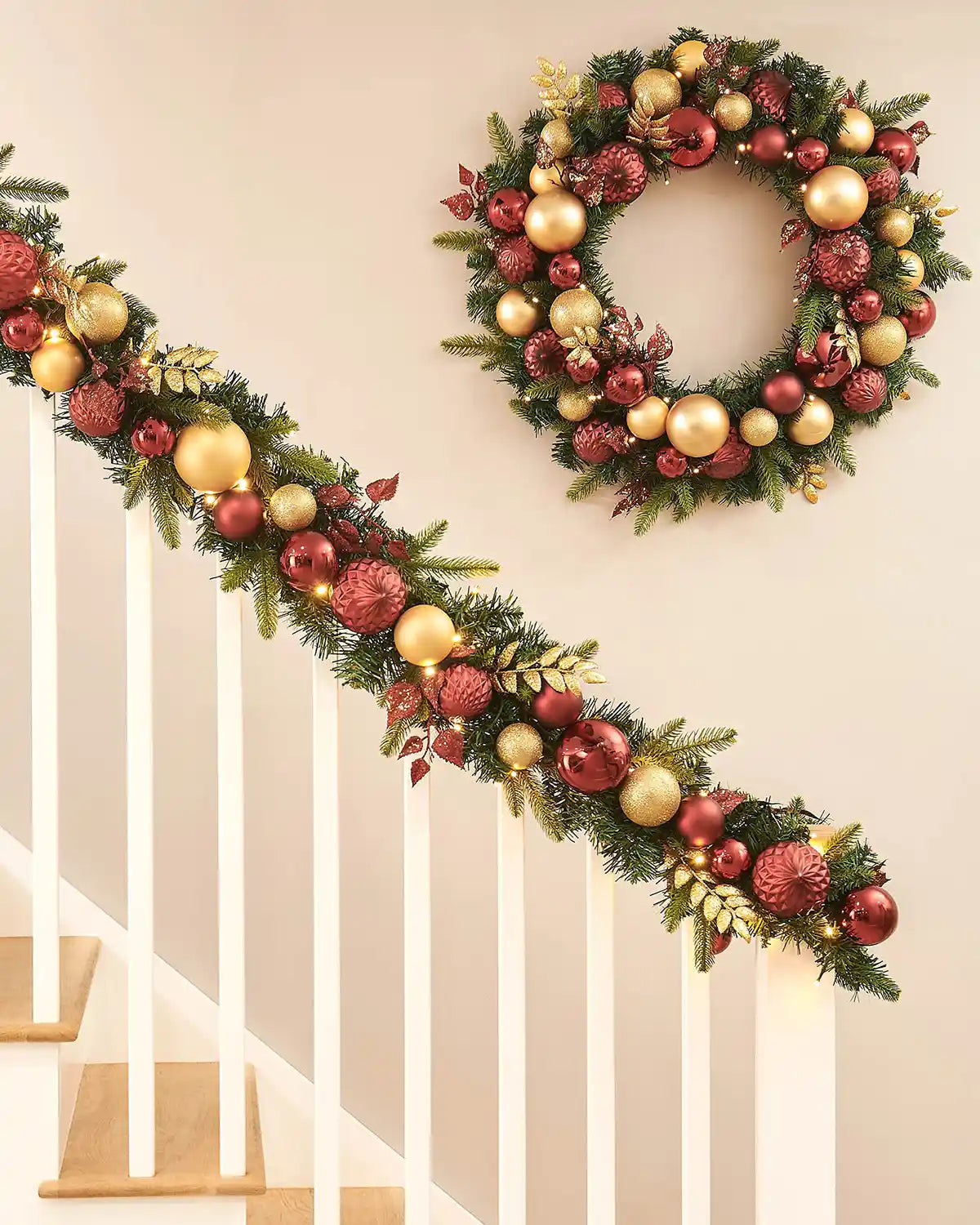 Decorative Christmas wreath and matching garland on a staircase with a neutral background