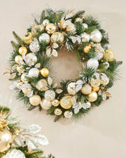Decorative Christmas wreath with gold, silver, and white baubles on a neutral background