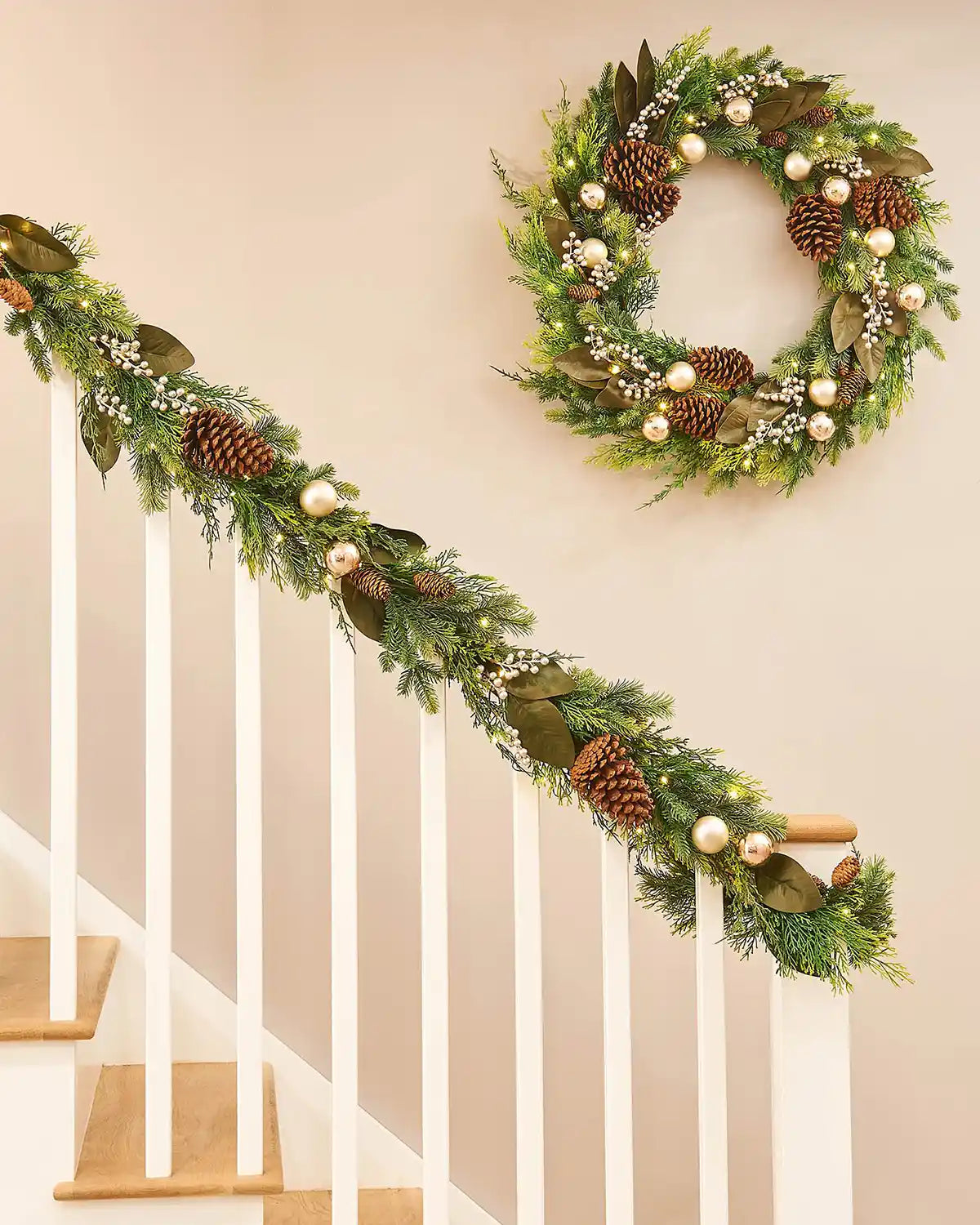 Decorative Christmas wreath with matching garland on a staircase banister with a neutral background