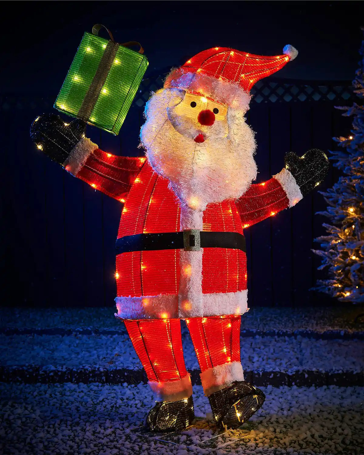 Decorative LED Santa Claus figure holding a gift box against a dark background.