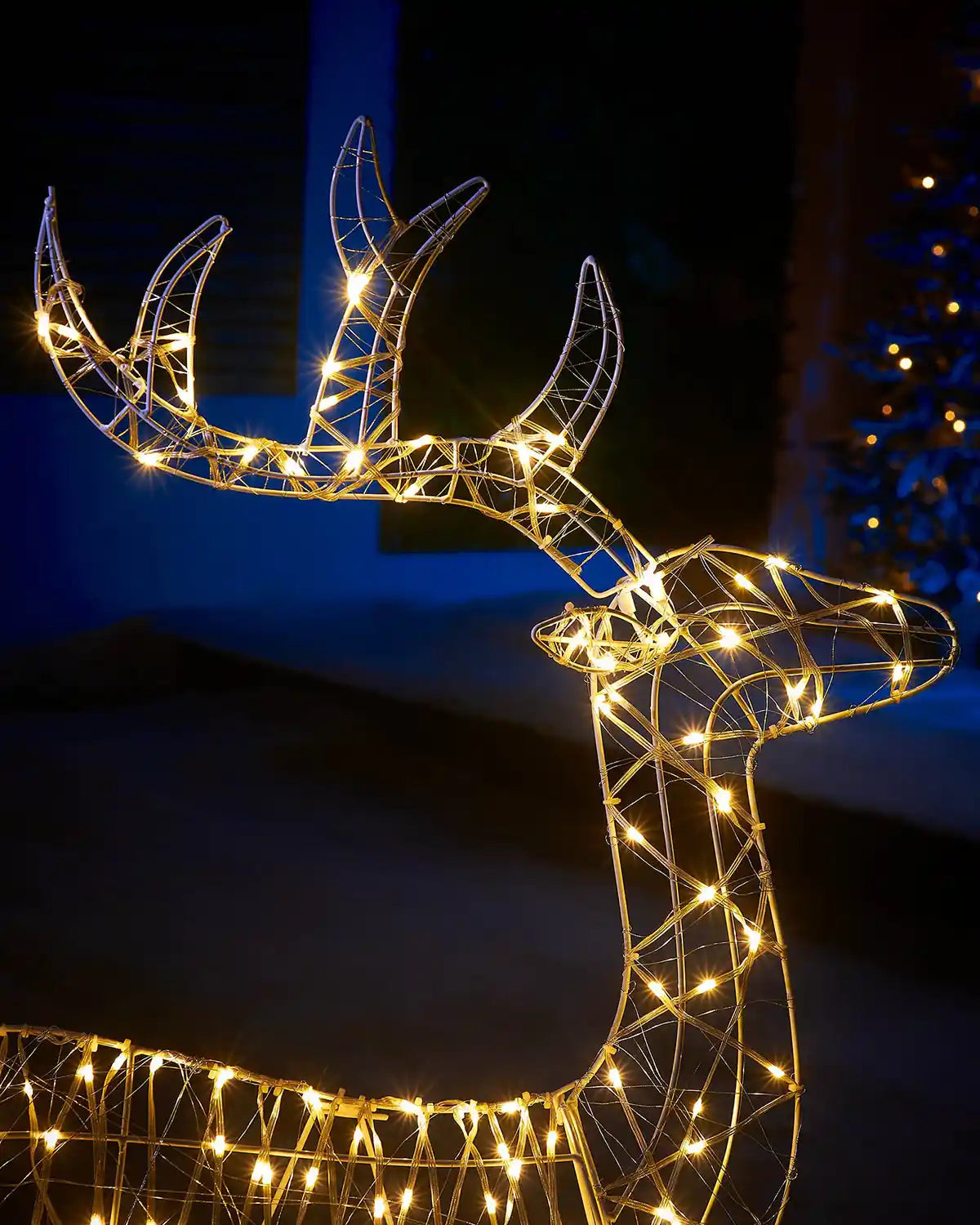 Decorative LED deer figure with string lights against a dark background
