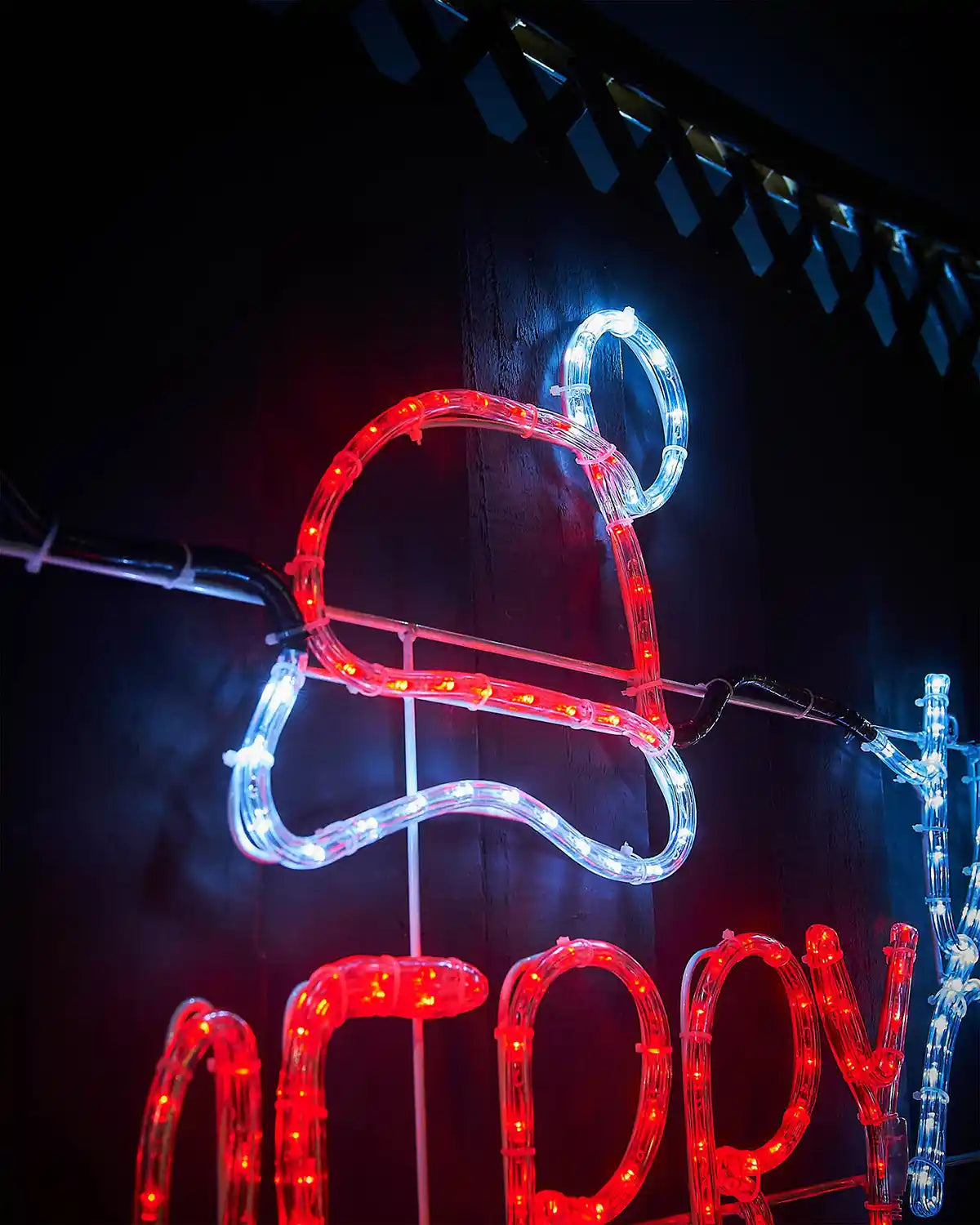 Decorative LED sign shaped like a Santa hat with 'Merry' text on a dark background
