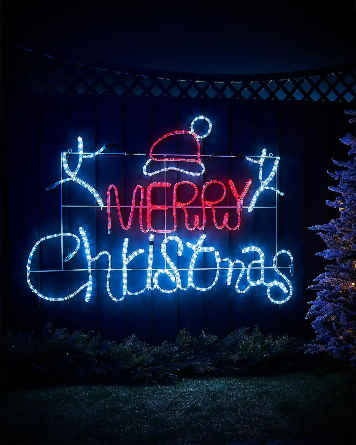 Decorative LED sign with 'Merry Christmas' text in ice white and red lights against a night time scene on a garden fence