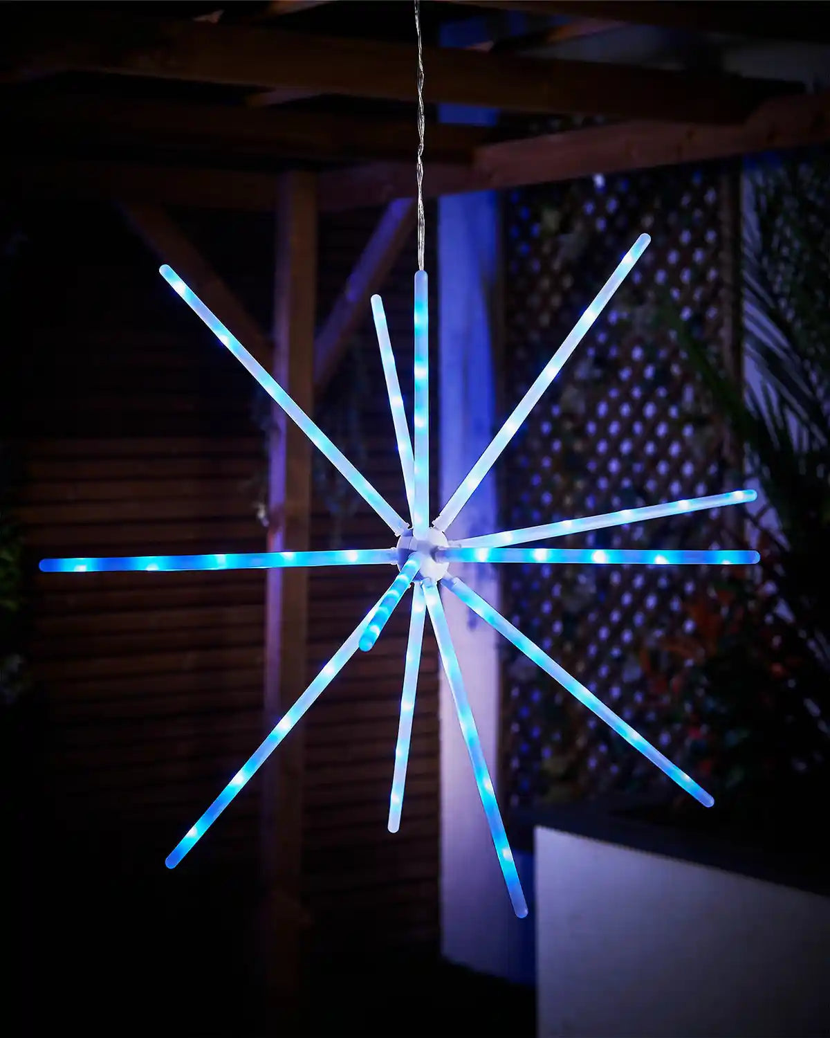 Decorative LED star-shaped light fixture with blue and white lights against a dark background.