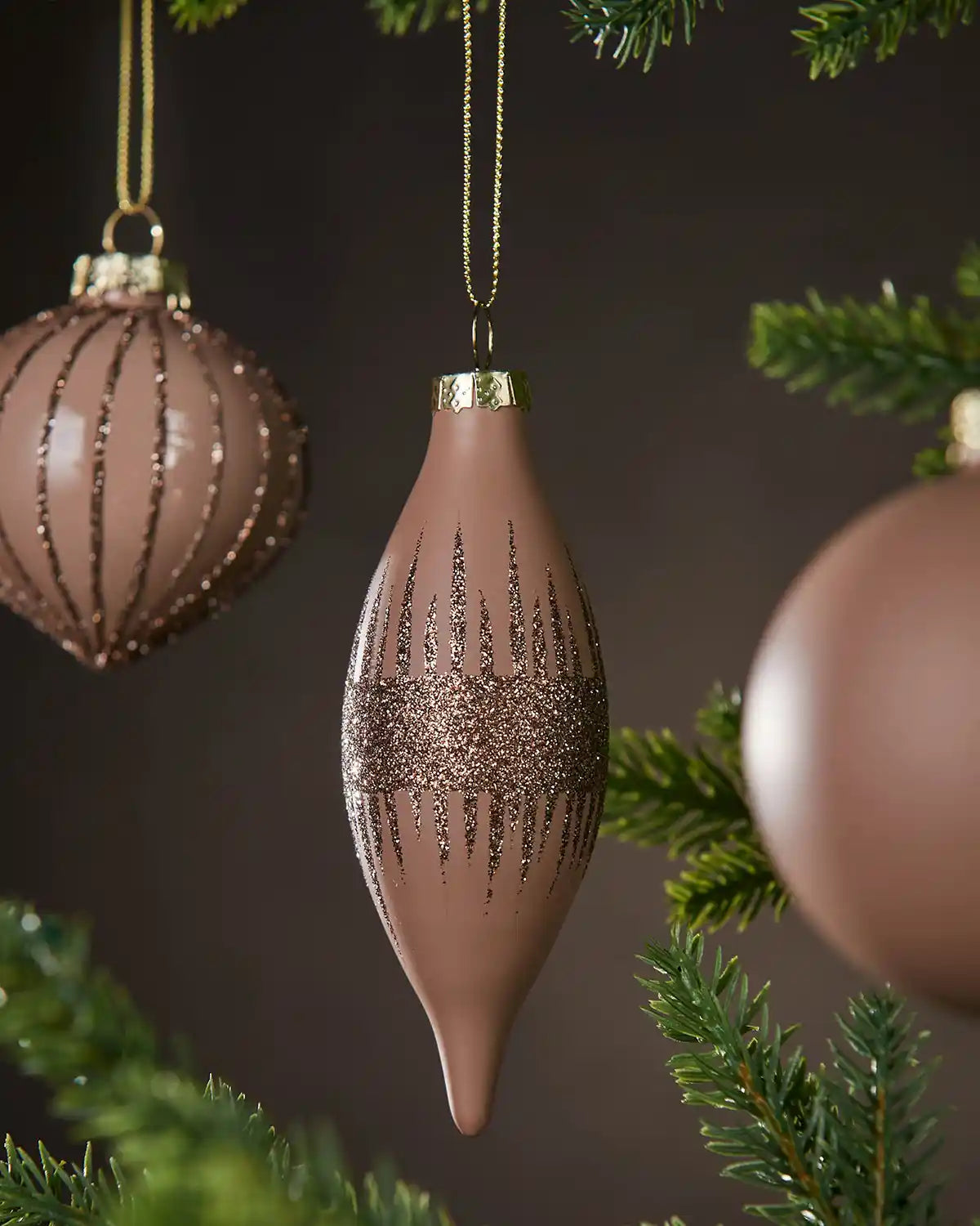 Decorative Latte Christmas baubles with a brown and gold design hanging on a tree.