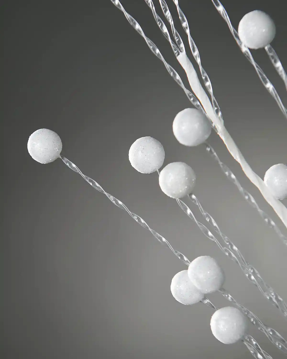 Decorative branch with white spherical berries style on a grey background