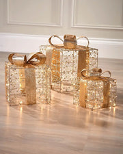 Decorative gold and copper gift boxes with LED lights on a wooden floor