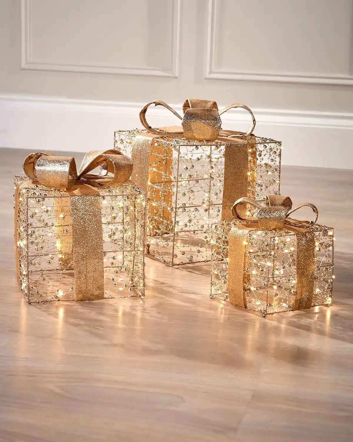 Decorative gold and copper gift boxes with LED lights on a wooden floor