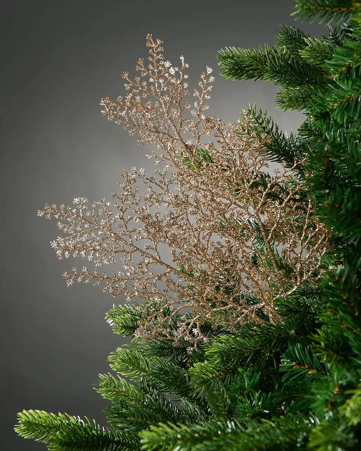 Decorative gold glitter artificial plant stem with small branches on a Christmas tree 