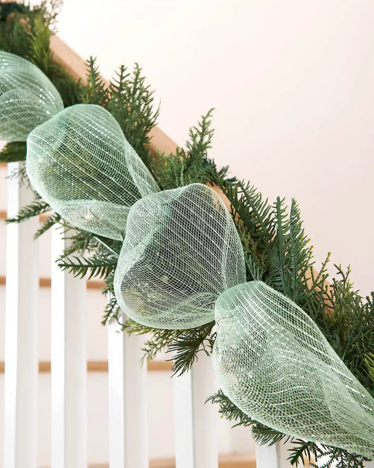 Decorative green mesh ribbon on a Christmas garland with a neutral background