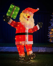 Decorative light-up Santa Claus figure holding a gift against a dark background