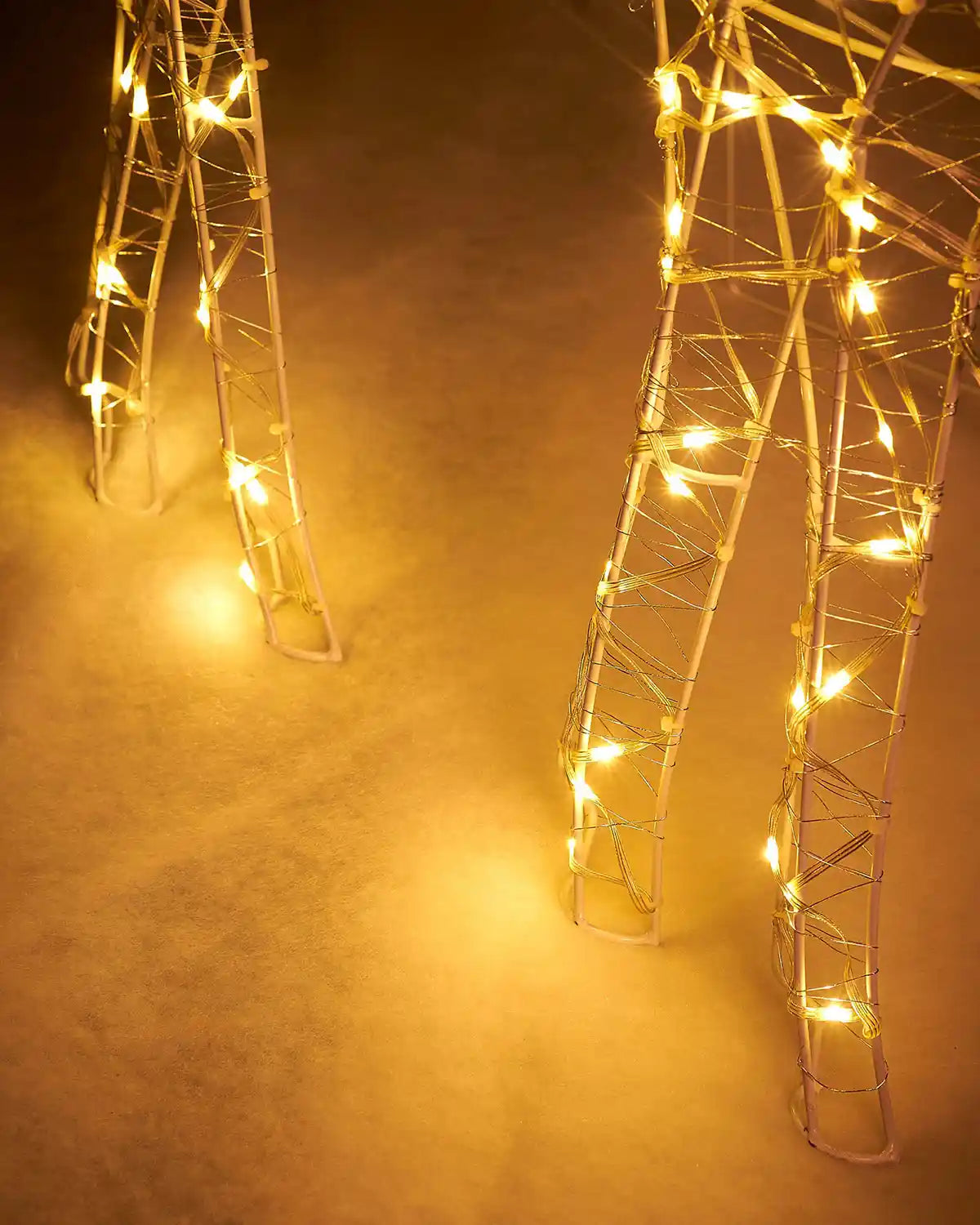 Decorative metal legs with string lights on a snowy background