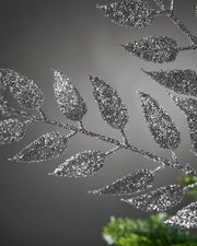 Decorative metallic leaf branch against a gray background