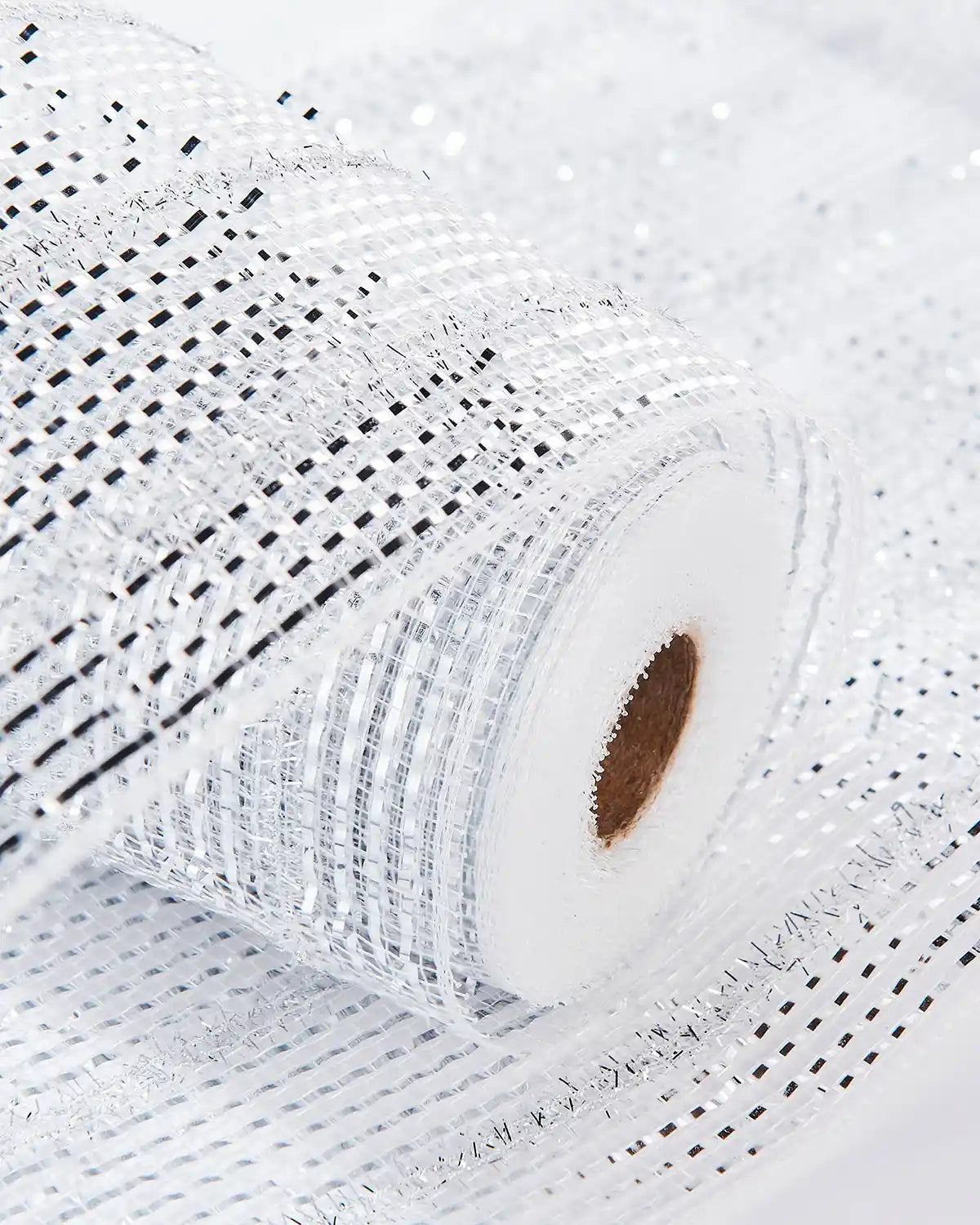 Decorative transparent silver mesh ribbon on a white table