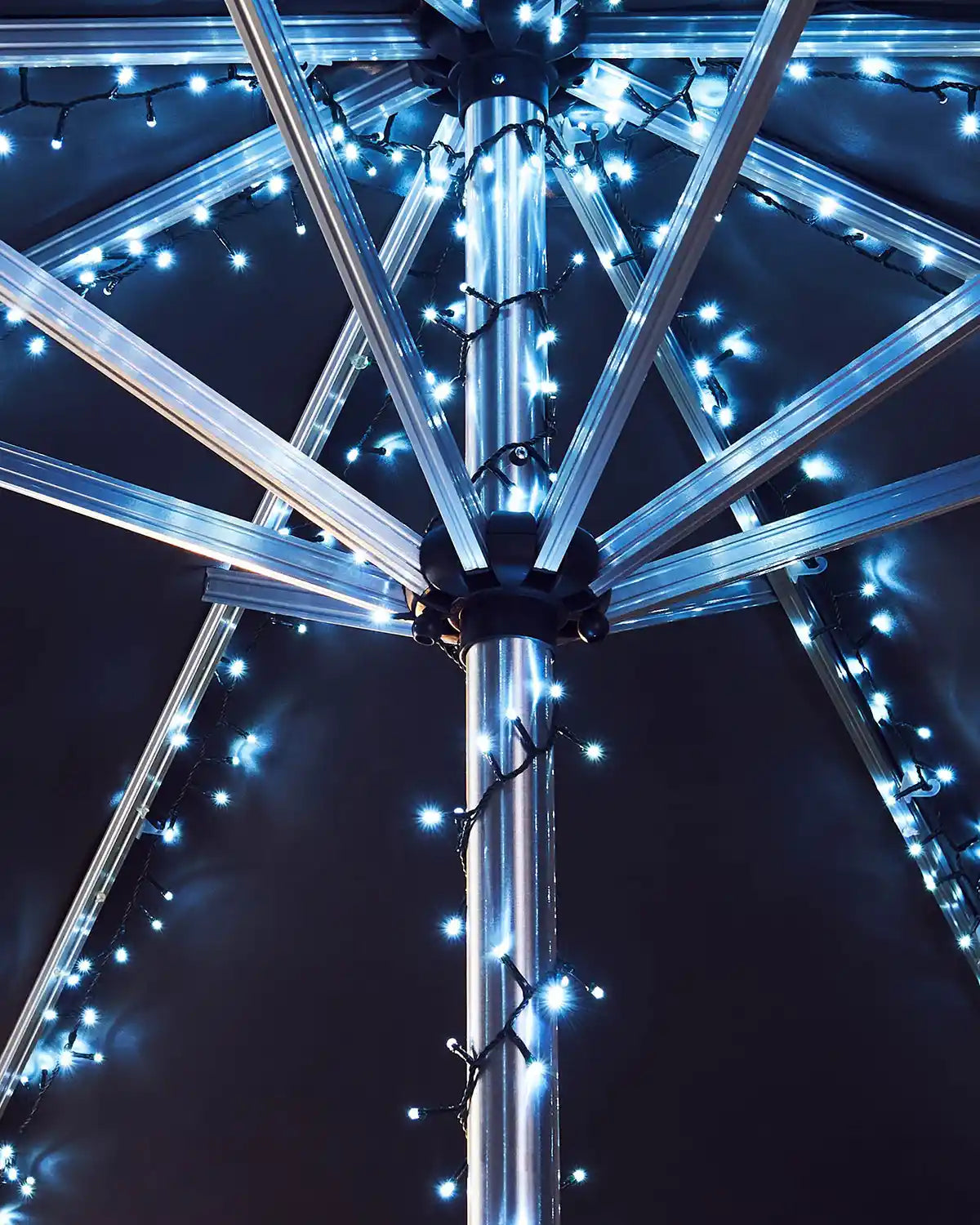 Decorative umbrella with ice white LED lights against a dark background