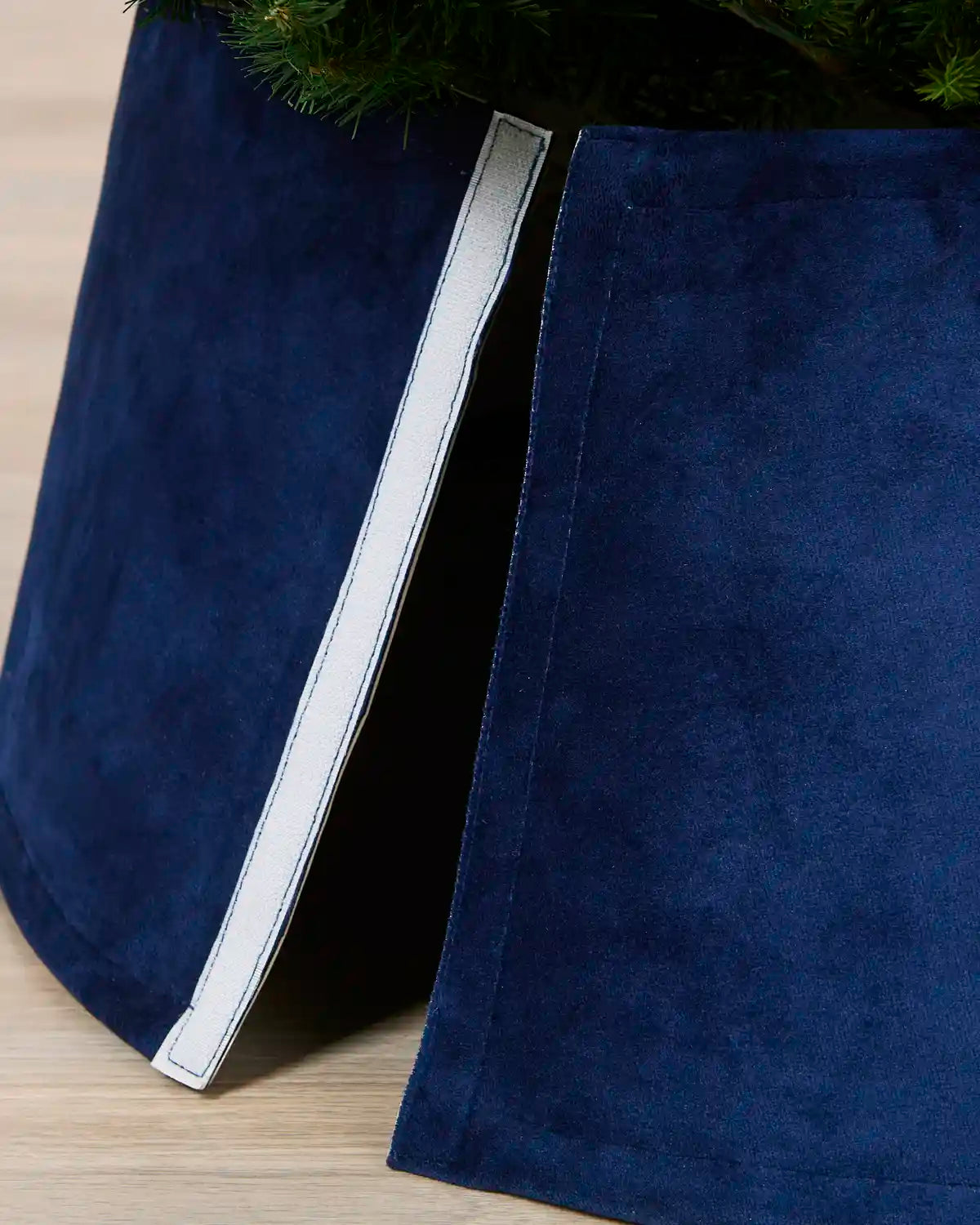 Detail of the Navy velvet tree skirt opened at the back, showing the Velcro closure used to secure it around the tree
