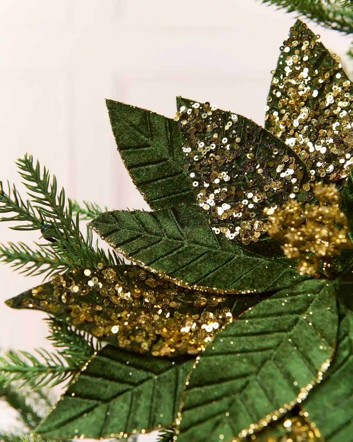 Detailed close-up of a Sage Green & Gold artificial poinsettia flower, showing its glittered gold petals and sparkling gold sequin-covered center
