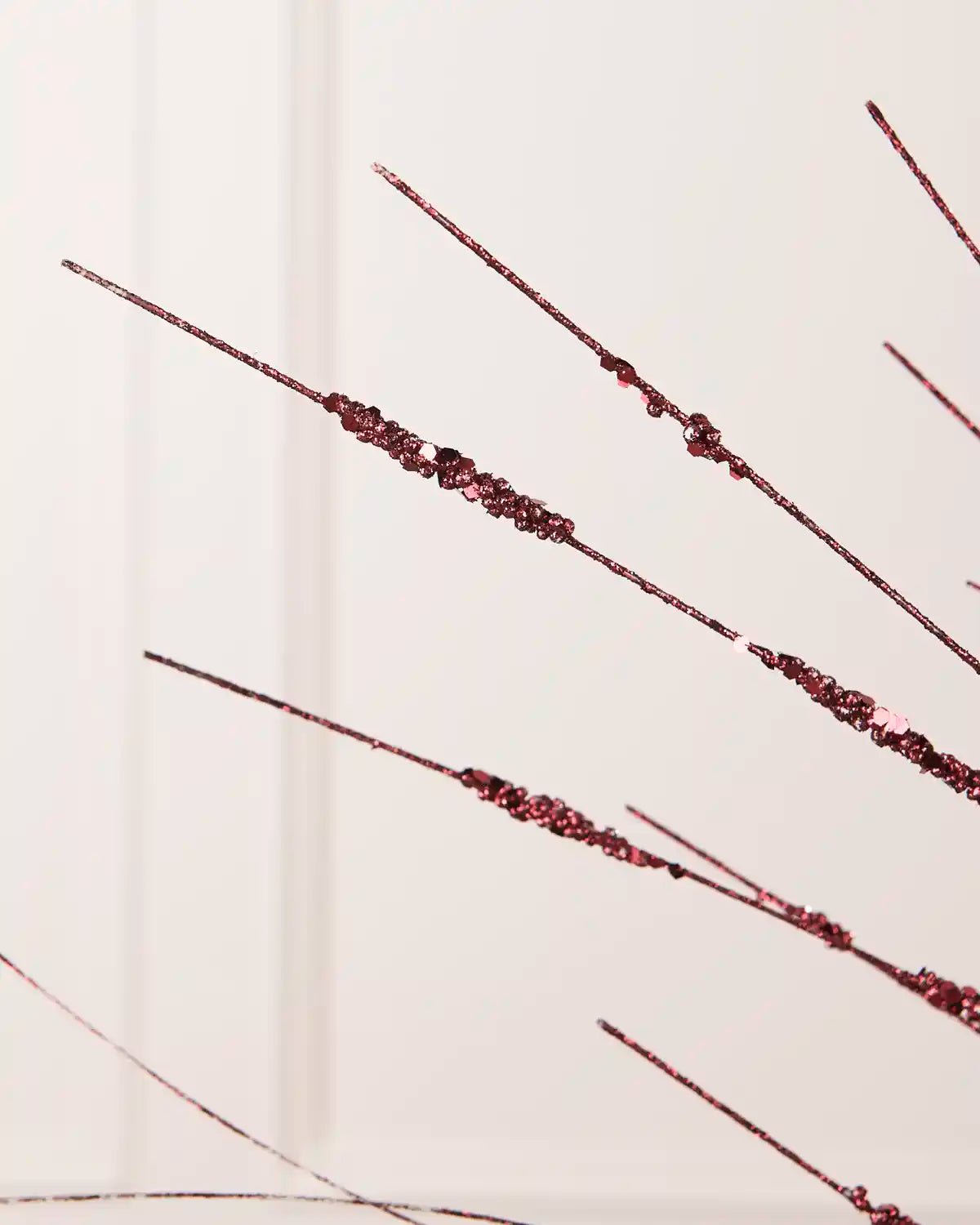 Detailed close-up of slender Burgundy glitter stems with textured sections from the Glitter Wispy Spray