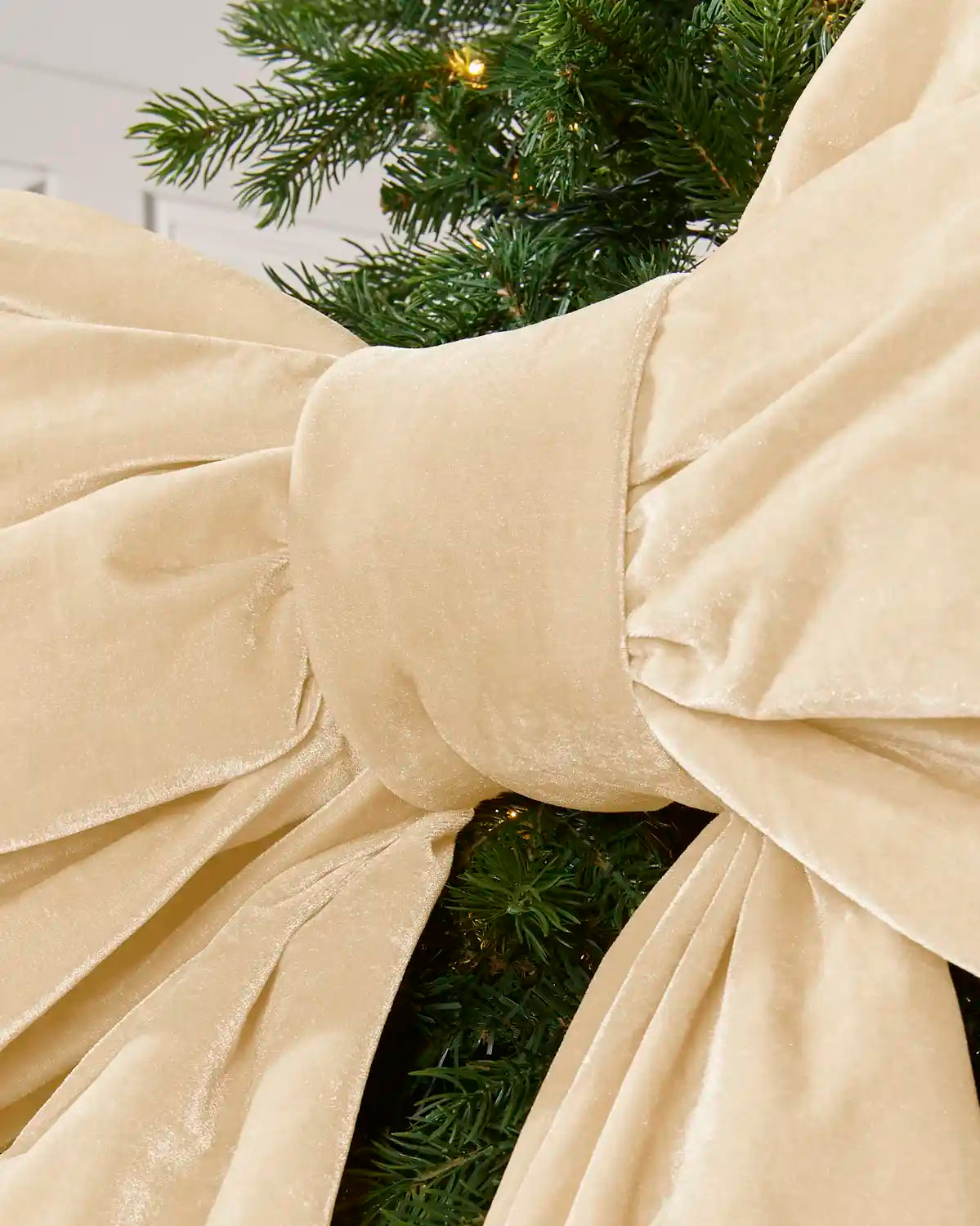 Detailed close-up of the 140 cm latte velvet Christmas bow showing the padded centre knot and gathered fabric.
