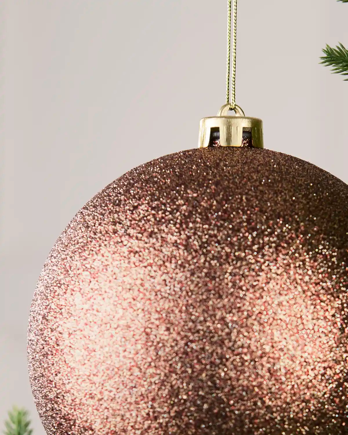 Detailed close-up of the Glitter 15 cm Espresso shatterproof bauble with its gold cap and matching hanging string.