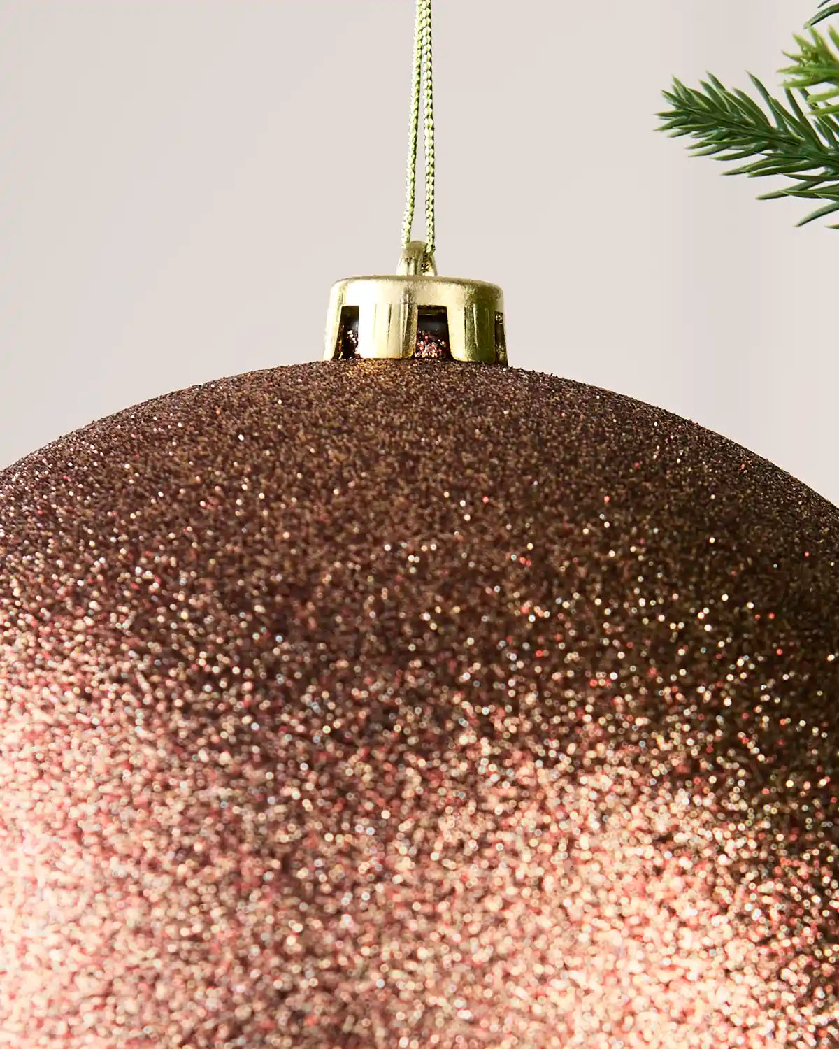 Detailed close-up of the Glitter 20 cm Espresso shatterproof bauble with its gold cap and matching hanging string.