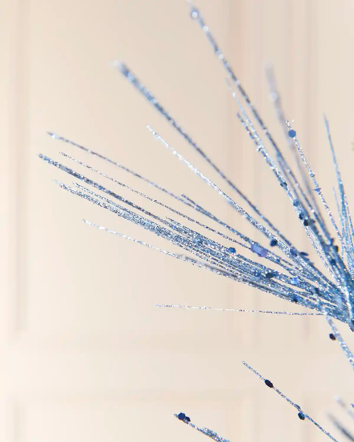 Detailed close-up of the Ice Blue Glitter Firework Spray, highlighting its fine glitter-covered stems and small decorative accents against a light background
