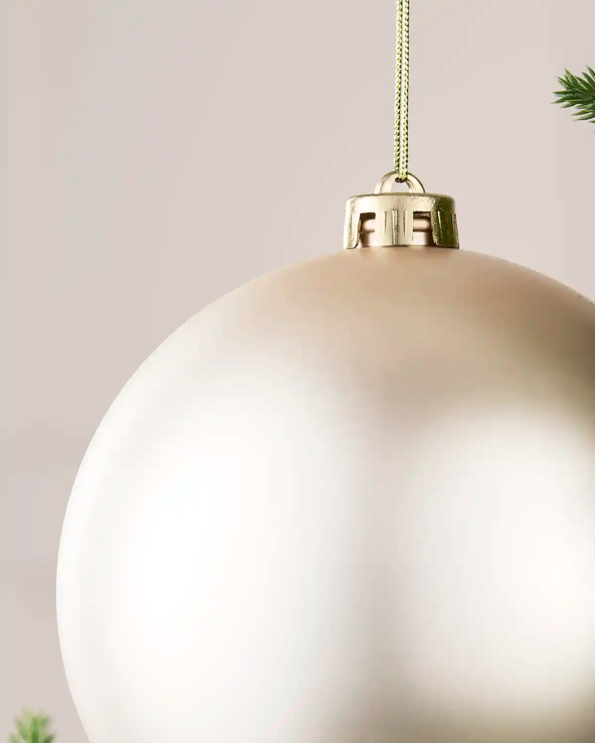 Detailed close-up of the Latte 15 cm matt shatterproof bauble with its gold cap and matching hanging string.