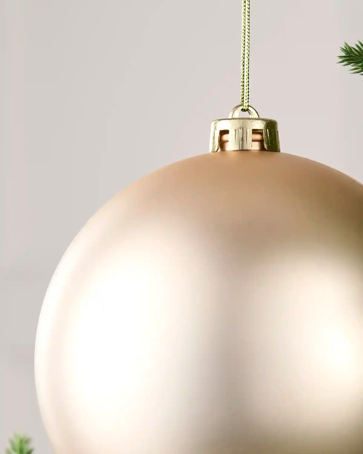 Detailed close-up of the Latte 15 cm matt shatterproof bauble with its gold cap and matching hanging string.