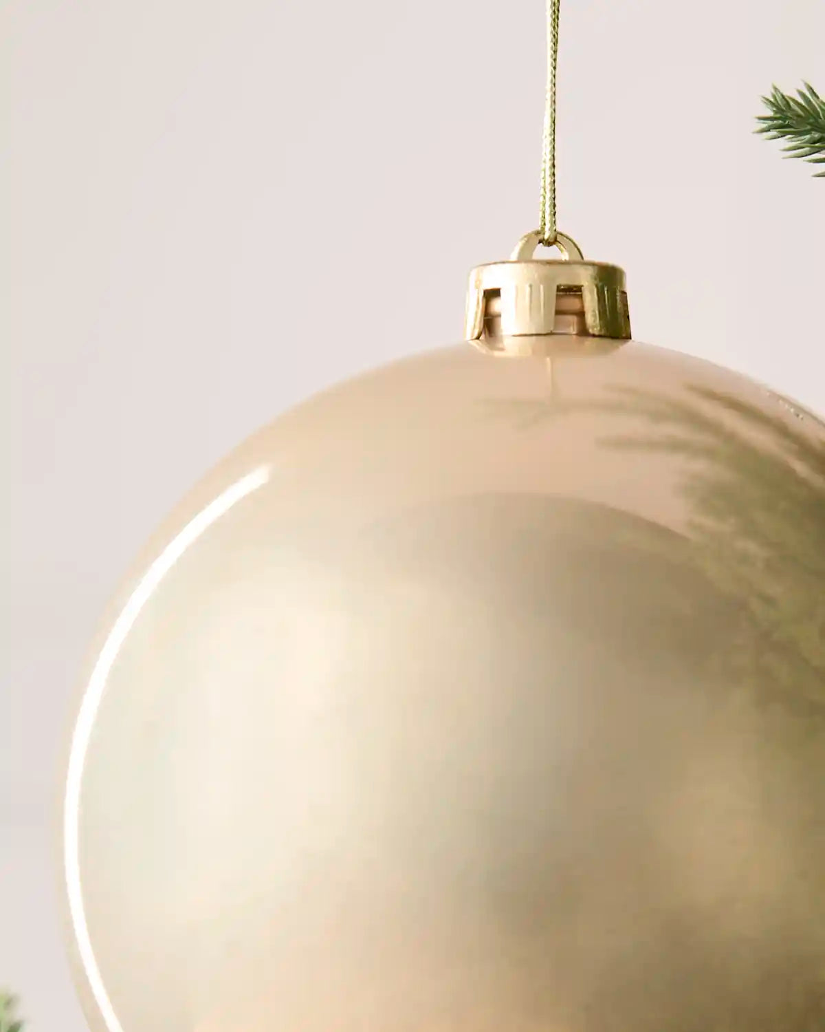 Detailed close-up of the Latte 15 cm shiny shatterproof bauble with its gold cap and matching hanging string.