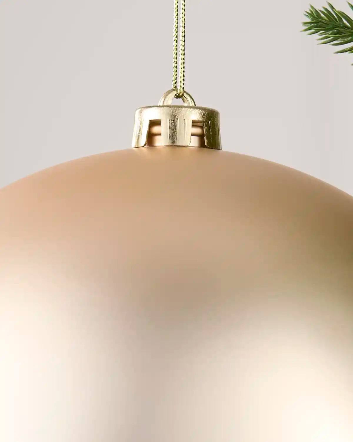 Detailed close-up of the Latte 20 cm matt shatterproof bauble with its gold cap and matching hanging string.