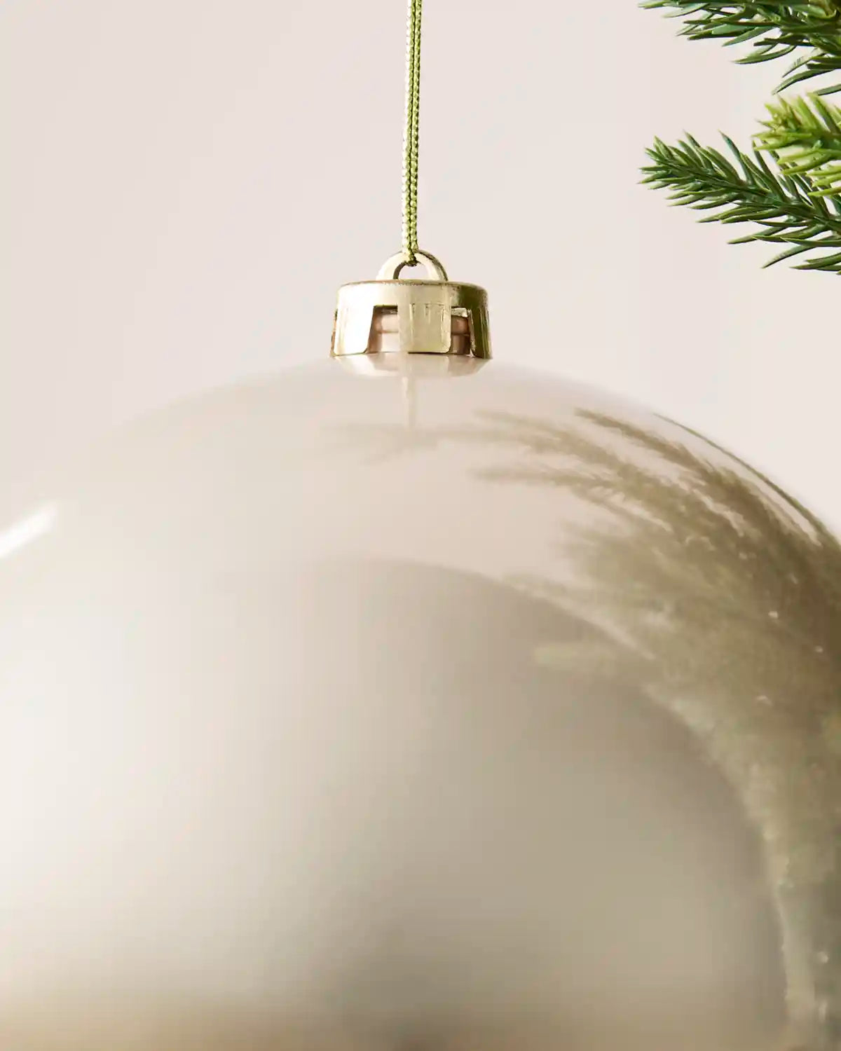 Detailed close-up of the Latte 20 cm shiny shatterproof bauble with its gold cap and matching hanging string.