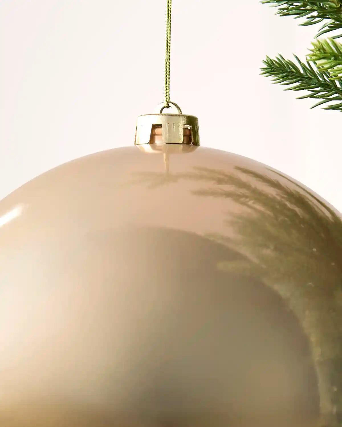 Detailed close-up of the Latte 20 cm shiny shatterproof bauble with its gold cap and matching hanging string.