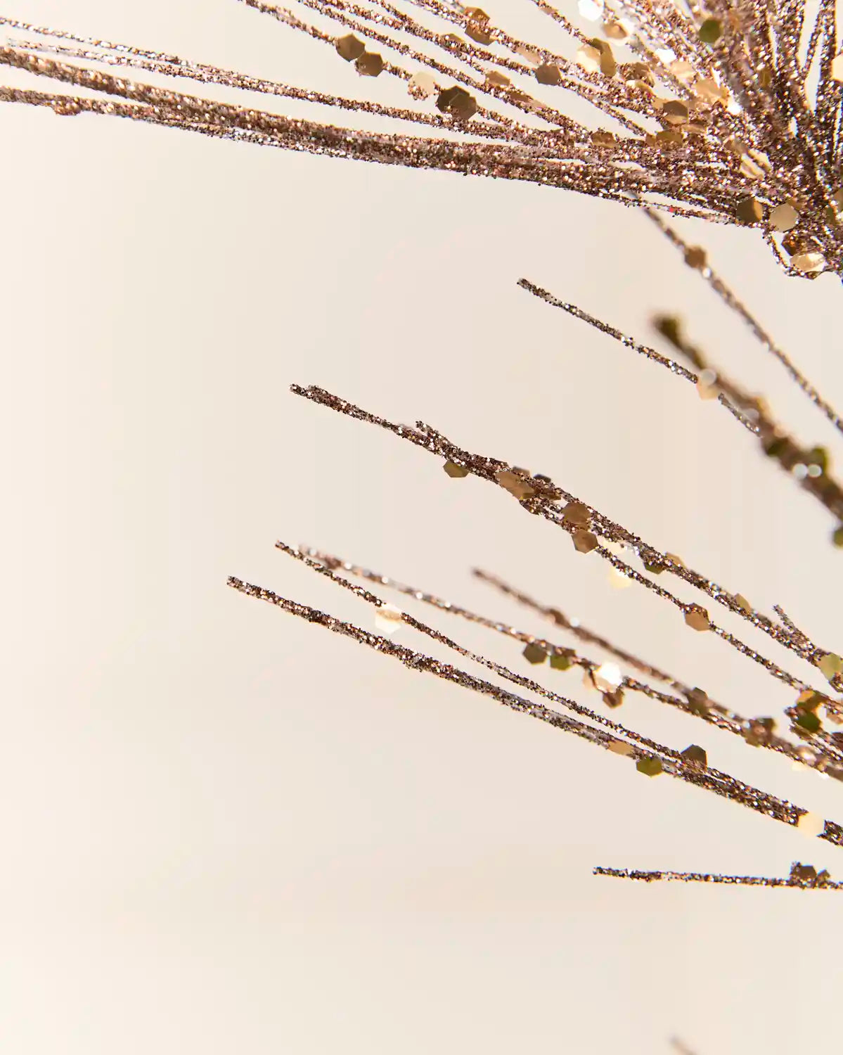 Detailed close-up of the Mocha Glitter Firework Spray, highlighting its fine glitter-covered stems and small decorative accents against a light background