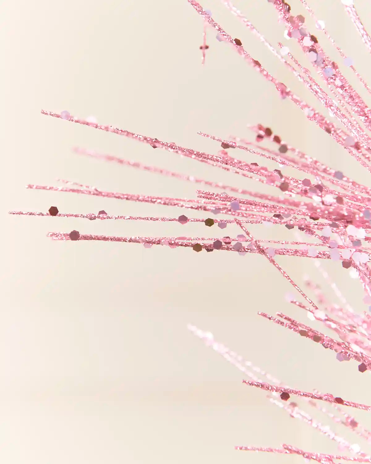 Detailed close-up of the Pink Glitter Firework Spray, highlighting its fine glitter-covered stems and small decorative accents against a light background