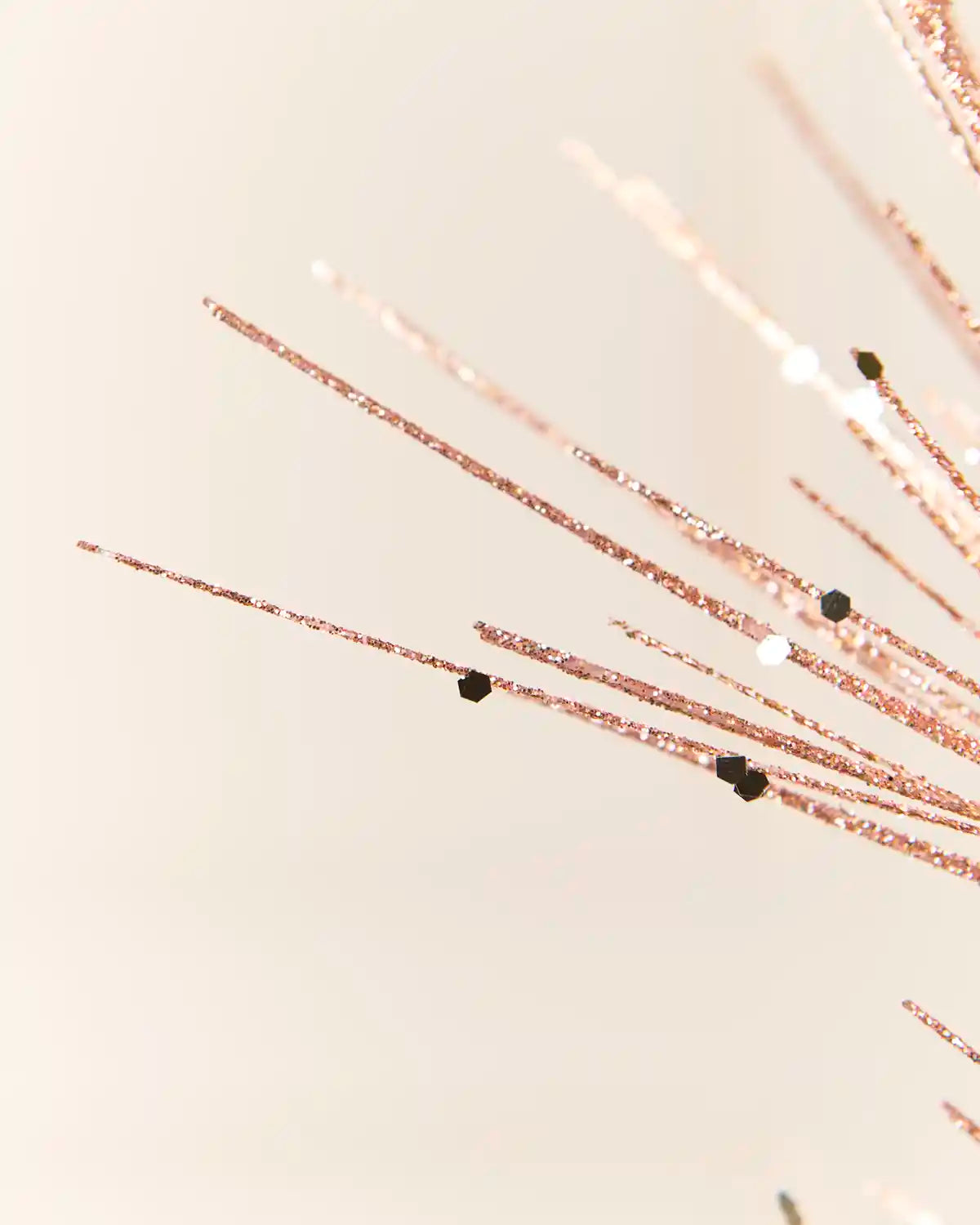 Detailed close-up of the  Rose Gold  Glitter Firework Spray, highlighting its fine glitter-covered stems and small decorative accents against a light background