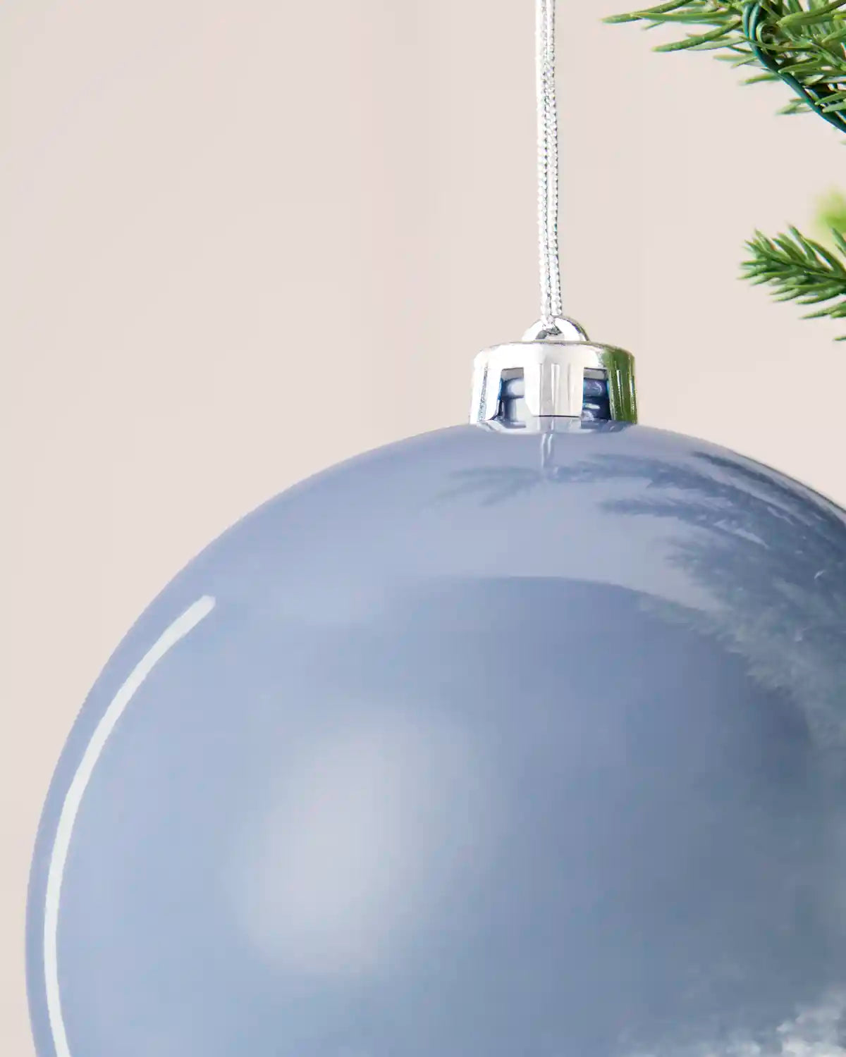 Detailed close-up of the ice blue 15 cm shiny shatterproof bauble with its silver cap and matching hanging string.