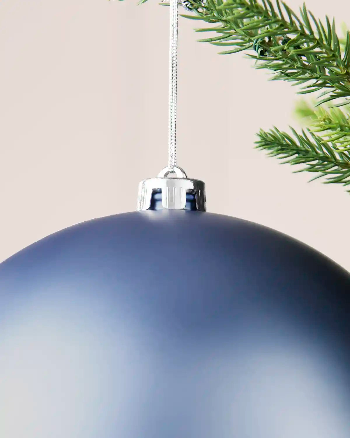 Detailed close-up of the ice blue 20 cm matt shatterproof bauble with its silver cap and matching hanging string.