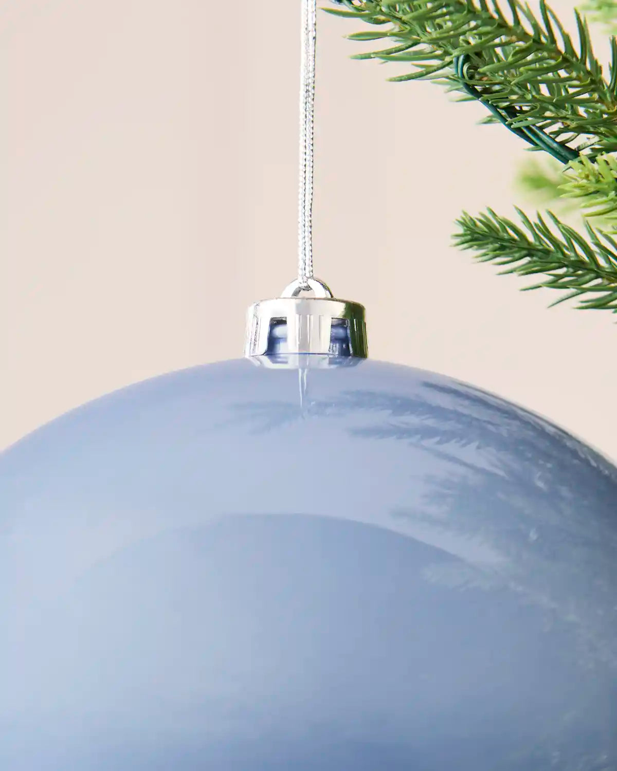 Detailed close-up of the ice blue 20 cm shiny shatterproof bauble with its silver cap and matching hanging string.