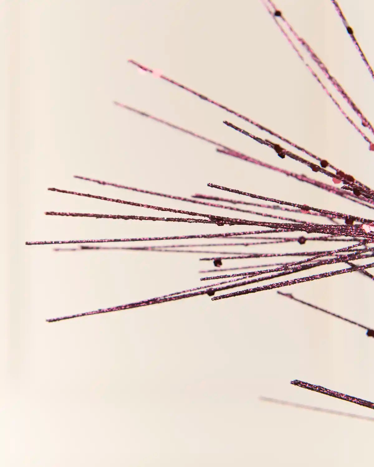 Detailed close-up of the purple Glitter Firework Spray, highlighting its fine glitter-covered stems and small decorative accents against a light background